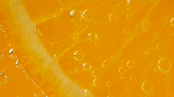 Kawałek Dojrzałej Pomarańczy Bąbelkach Wody Pomarańczowym Tle — Wideo stockowe
