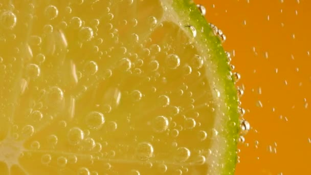 Slice Ripe Lime Air Bubbles Orange Background — Stockvideo