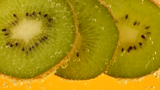 Ripe Kiwi Slices Air Bubbles Orange Background — Stockvideo