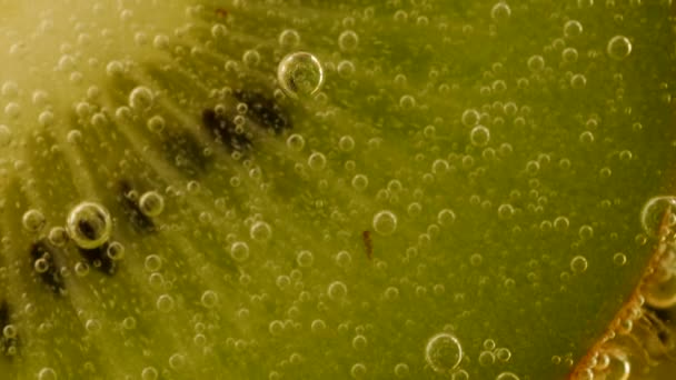Ripe Kiwi Slices Air Bubbles Orange Background — стоковое видео