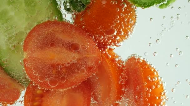Slices Fresh Cucumbers Tomatoes Clear Water Air Bubbles — Vídeo de stock