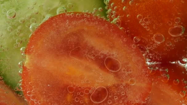 Slices Fresh Cucumbers Tomatoes Clear Water Air Bubbles — Stok video