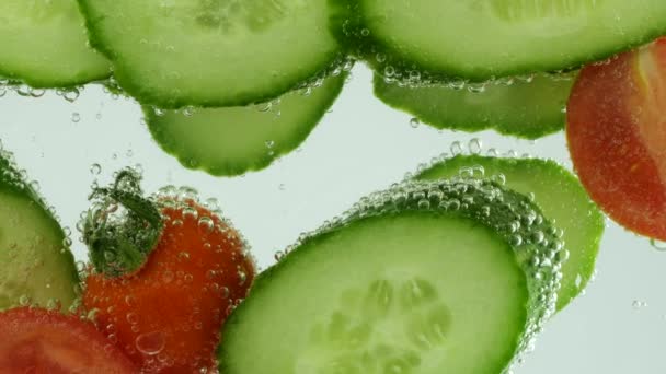 Slices Fresh Cucumbers Tomatoes Clear Water Air Bubbles — Wideo stockowe