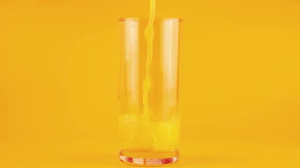 Апельсиновый Сок Наливают Стеклянный Кубок Оранжевом Фоне Медленное Движение — стоковое видео