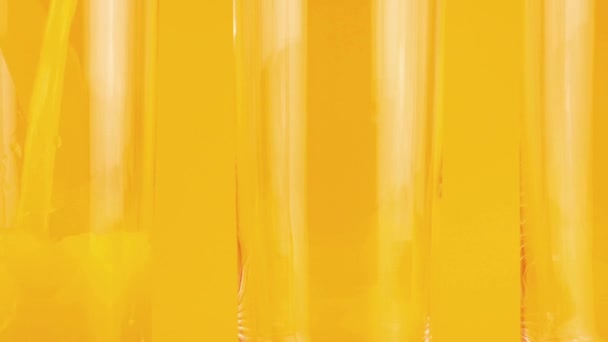 Sinaasappelsap Wordt Een Oranje Achtergrond Glazen Bekers Gegoten Langzame Beweging — Stockvideo
