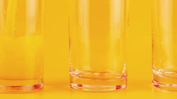 橙汁倒入橙色背景的玻璃杯中 慢动作 — 图库视频影像