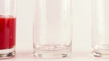 Domates suyu cam bardaklara dökülür. Yavaş çekim.