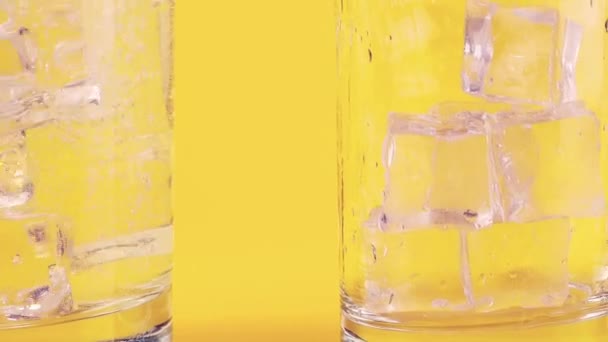 Carbonated Limonade Wordt Gegoten Glazen Bekers Met Ijs Gele Achtergrond — Stockvideo