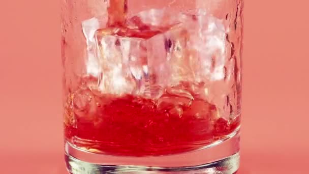 Sok Granatu Wlewa Się Szklanych Pucharów Lodem Różowym Tle Zwolniony — Wideo stockowe