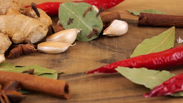 在生姜根 红辣椒 月桂叶和大蒜的背景下 把干丁香芽放在木板上 — 图库视频影像