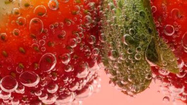 Pembe arka planda, hava kabarcıklarında olgun çilekler..