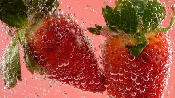 粉红背景的气泡中成熟的草莓 — 图库视频影像
