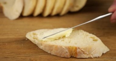 Tahta kesme tahtasının üzerinde kırmızı havyarla beyaz ekmek ve tereyağından sandviç pişirmek..