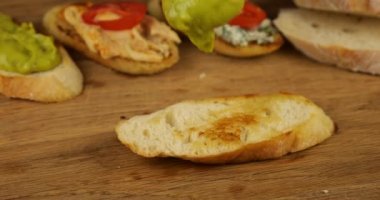 Guacamole bir parça kızarmış ekmekle çeşitli mezelerin arka planında kaşıkla yenir. Vejetaryenler için yiyecek..