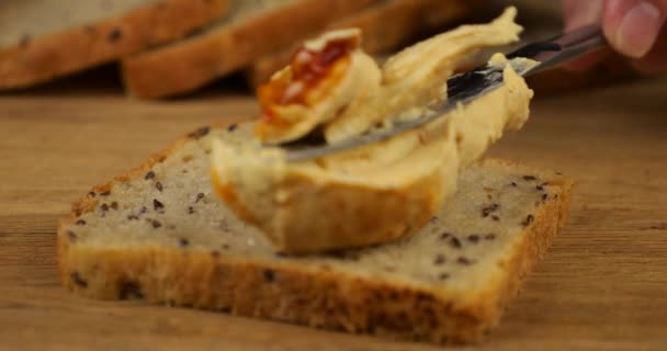 Hummus Rozkłada Się Nożem Kawałku Wieloziarnistego Chleba Drewnianej Desce Krojenia — Wideo stockowe