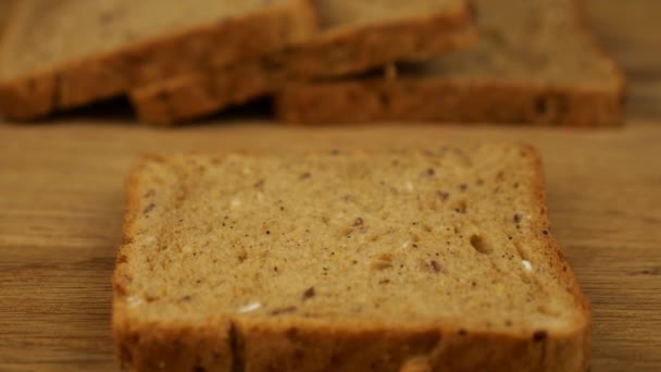 Tereyağı Tahta Kesme Tahtasındaki Çoklu Tahıllı Ekmeğin Üzerine Bir Bıçakla — Stok video