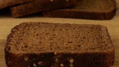 Tereyağı, tahta kesme tahtasındaki çavdar ekmeğine bıçak ile sürülmüş..