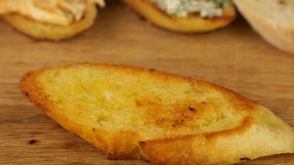在烤面包上 在各种开胃菜的背景下 用一把小刀将鹰嘴豆铺在烤面包上 为素食者提供食物 — 图库视频影像
