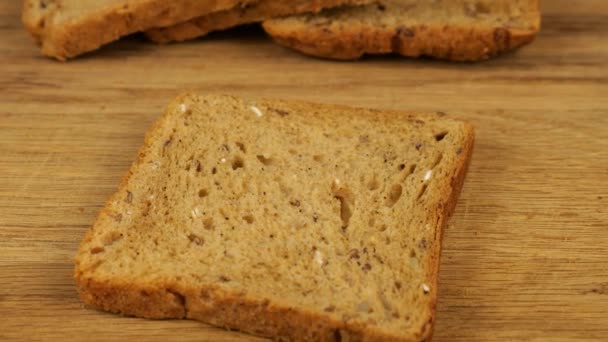 鹰嘴豆是用一把小刀铺在一块木制切菜板上的多粒面包上的 为素食者提供食物 — 图库视频影像