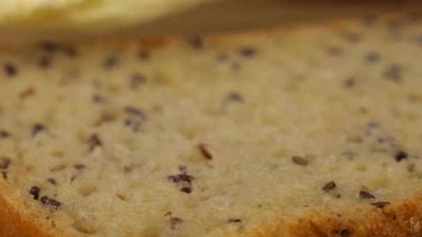 Masło Rozkłada Się Nożem Kawałku Wieloziarnistego Chleba Drewnianej Desce Krojenia — Wideo stockowe