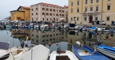 Evlerin ve teknelerin sularında yansıma. Piran, Slovenya.