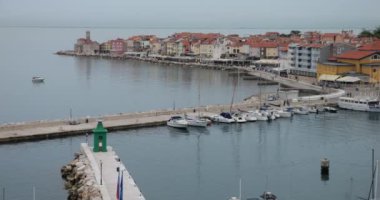 Piran 'ın kırmızı kiremitli çatılarının panoramik hava manzarası, çan kulesi, liman ve botlar, güneşli bir sabahta Adriyatik Denizi sakin. Slovenya.