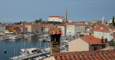 Piran 'ın kırmızı kiremitli çatılarının panoramik hava manzarası, çan kulesi, liman ve botlar, güneşli bir sabahta Adriyatik Denizi sakin. Slovenya.