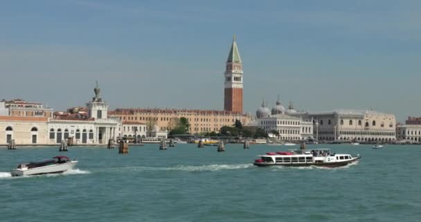 从船上观看Punta Della Dogana Giudecca运河和砖房 圣马克坎帕尼勒 圣马可广场 Piazza San Marco 多吉宫以及在意大利威尼斯运河上航行的汽艇和汽艇 — 图库视频影像