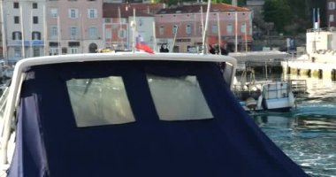 Uçan bir balıkçı teknesi sabahın erken saatlerinde Slovenya 'nın Piran limanından ayrılıyor. Siyah bayraklar büyük ihtimalle denizdeki balık ağlarının yerini gösteriyor..