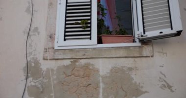 Eski bir evin duvarı, panjurlu pencereler..