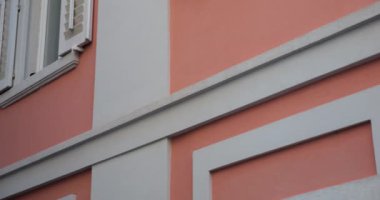 Akdeniz 'in eski bir kasabasında panjurlu, beyaz pencereli pembe bir ev..