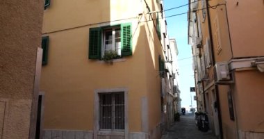 Eski Akdeniz kasabasında geleneksel evler, panjurlu pencereler, dar sokaklar ve güneşli bahar sabahlarında mavi gökyüzü..