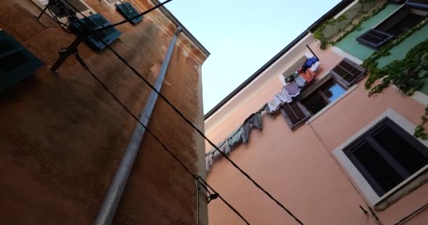 シャッター ツタで覆われた壁と屋外で乾燥するリネンを持つ古い地中海の町の伝統的な家 下から上への眺め — ストック動画