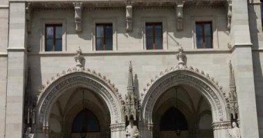 Macar Parlamento Binası neo-gotik tarzda ve rüzgarda dalgalanan Macar bayrakları. Budapeşte, Macaristan.
