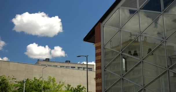 ブダペストの青い空と白い雲に対して近代的なガラスの壁と赤レンガの改修の建物 ハンガリー — ストック動画