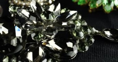 Eski moda bijouterie ve takılarla kadife kaplama vitrin. Kahverengi, beyaz, gri ve yeşil kristalli broşlar ve dumanlı kuvars gümüş yüzük..