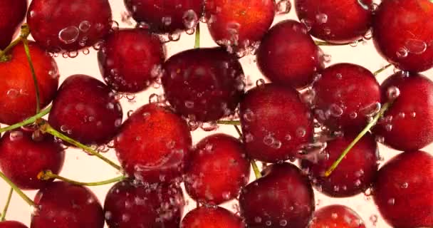 Édes Cseresznye Bogyók Víz Alatt Légbuborékok Rózsaszín Alapon — Stock videók