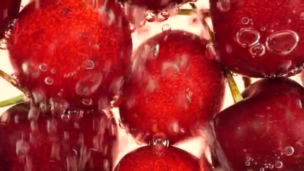 Zoete Kersenbessen Onder Water Luchtbellen Een Roze Achtergrond — Stockvideo
