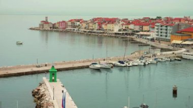 Piran 'ın kırmızı kiremitli çatılarının panoramik hava manzarası, çan kulesi, liman ve botlar, güneşli bir sabahta Adriyatik Denizi sakin. Slovenya.