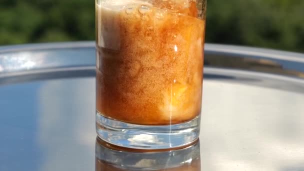 Cola Helles Glass Med Fra Appelsinjuice Mot Bakgrunnen Grønn Sommerskog – stockvideo