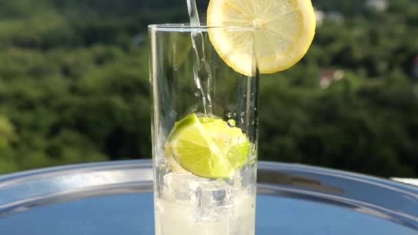 Limonata Viene Versata Bicchiere Ghiaccio Con Fette Lime Limone Sullo — Video Stock