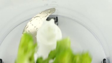 Parlak yeşil brokoli çiçekleri blender kasesine dökülür. Yavaş çekim.