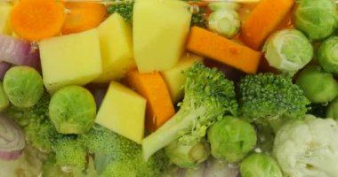 Kaynar suda hava kabarcıklarıyla çorba yapmak için sebze karışımı..