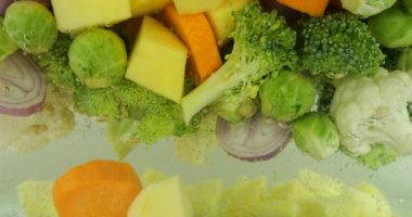 Kaynar suda hava kabarcıklarıyla çorba yapmak için sebze karışımı..