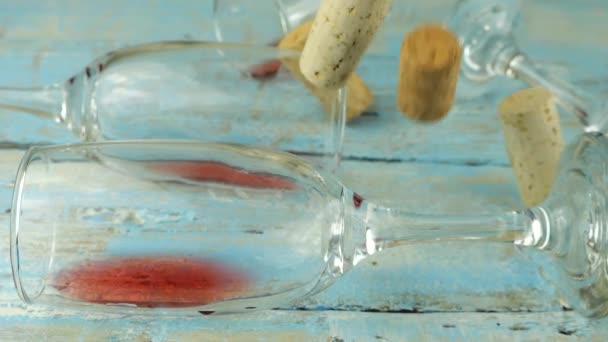 葡萄酒软木塞掉在蓝色木板上的装有红酒的玻璃杯上 慢动作 — 图库视频影像