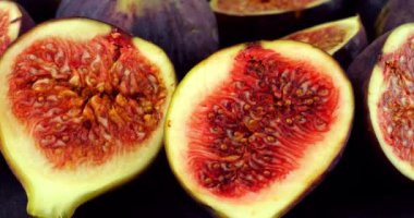 Siyah taş servis tahtasındaki incir ve incir dilimleri.