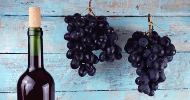 Weintrauben Und Weinflasche Auf Blauem Holzhintergrund — Stockvideo