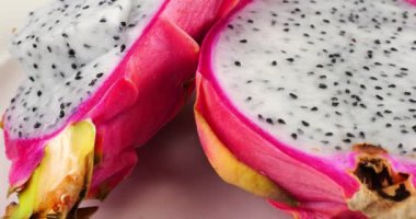 Tabakta iki dilim ejderha meyvesi Pitahaya dilimi.