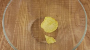 Patates cipsi cam kaseye düşüyor. Yavaş çekim.