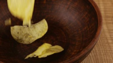 Patates cipsi seramik kaseye düşüyor. Yavaş çekim.